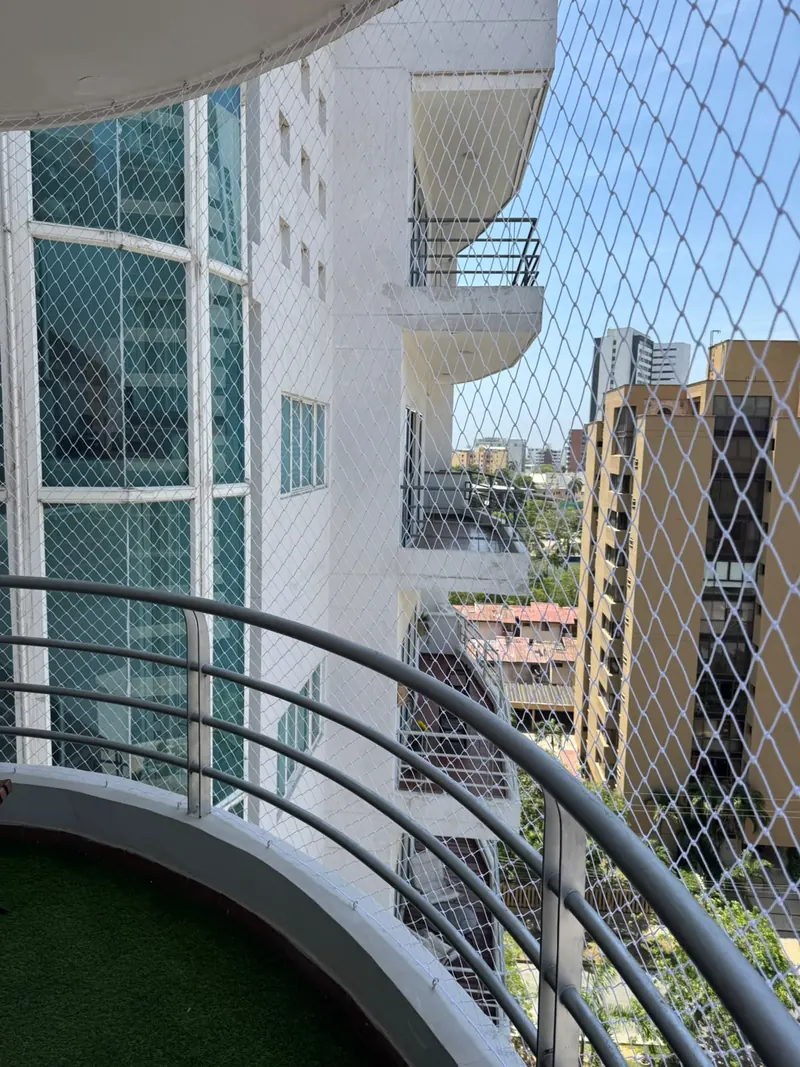 Balcón curvo de edificio residencial con malla de seguridad