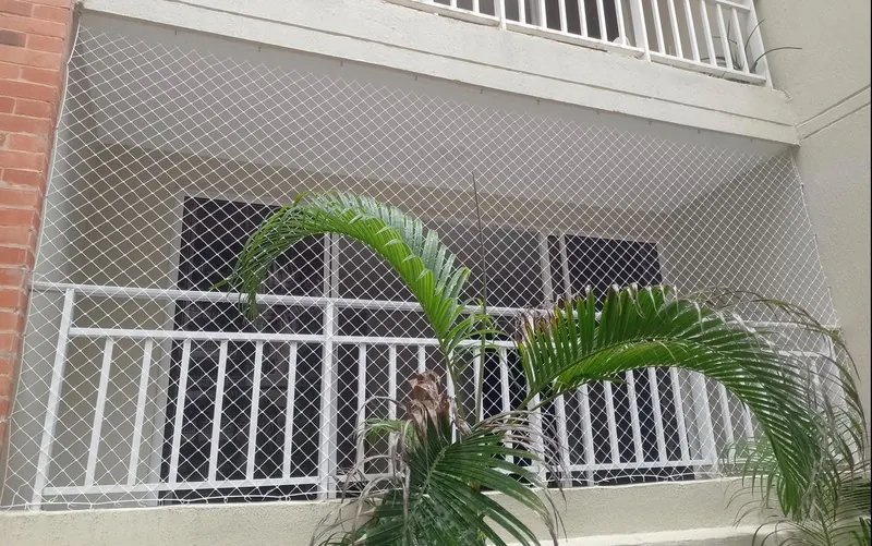 Balcón con baranda blanca y malla de seguridad